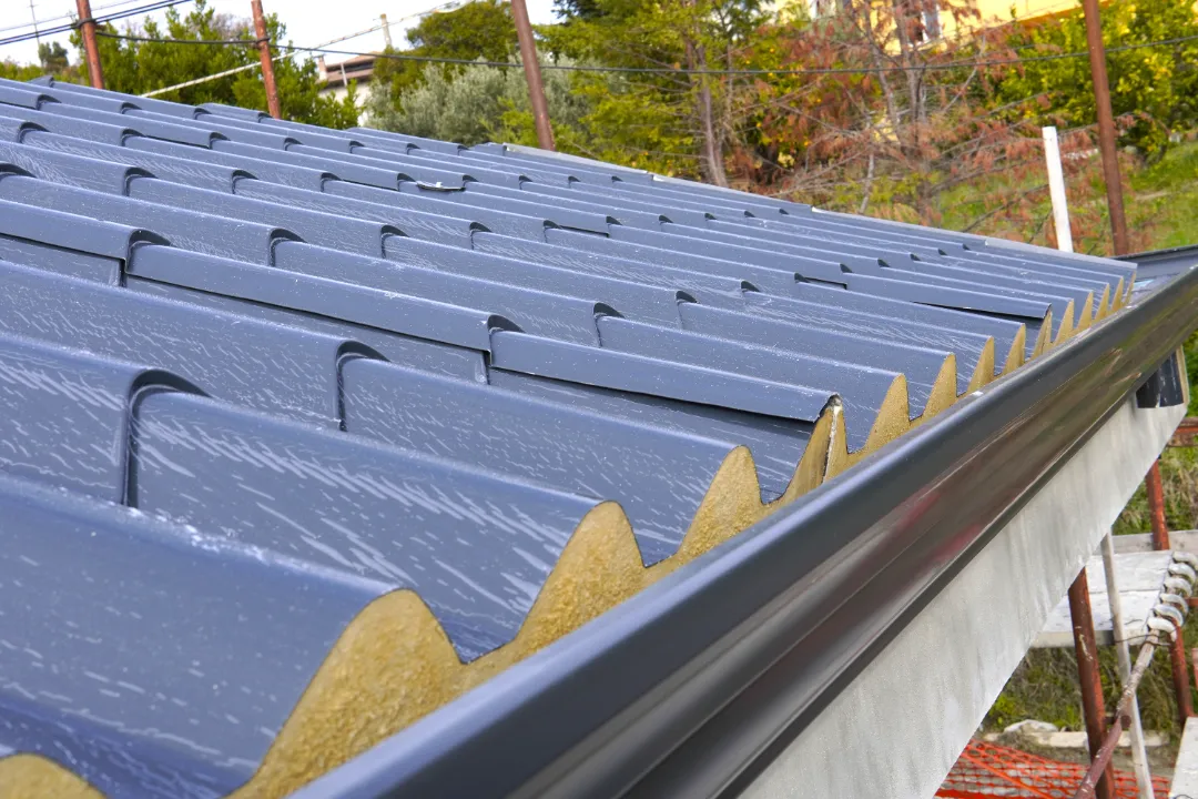 Solid conservatory roof installation showing insulation boards and blue tile effect cladding with anthracite gutter.